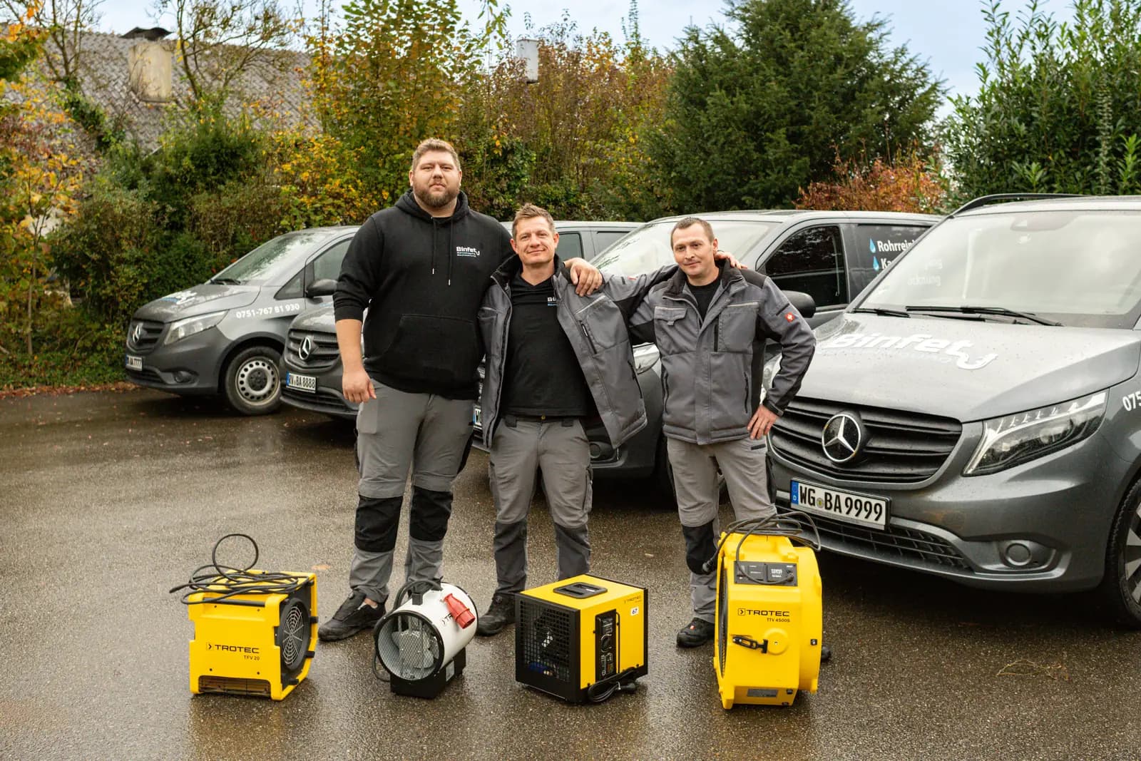 Team von Binfet Bautrocknung mit Trocknungsgeräten vor den Einsatzfahrzeugen in Ravensburg